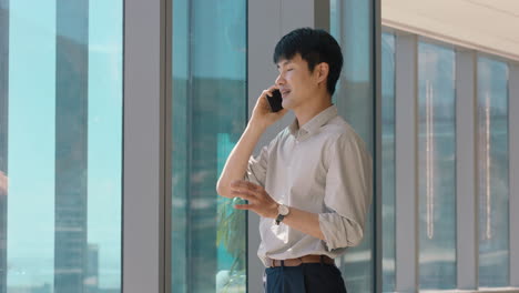 asian businessman using smartphone chatting to client financial advisor negotiating business deal corporate sales executive sharing expert advice having phone call in office looking out window