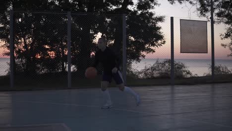 young woman basketball player training outdoors on a basketball court