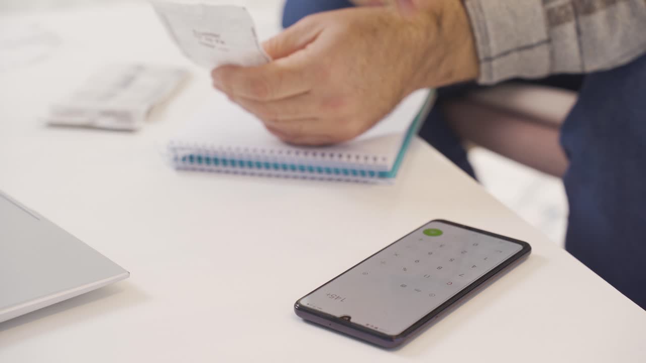 un primer plano de un hombre de familia calculando el presupuesto del hogar.