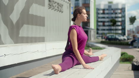 woman practicing yoga splits outdoors