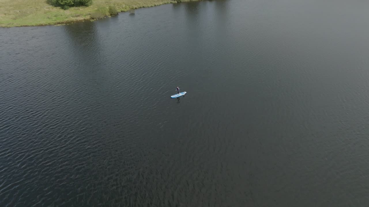 스탠드업 패들보드 위에 서 있는 젊은 여성의 클로징 샷