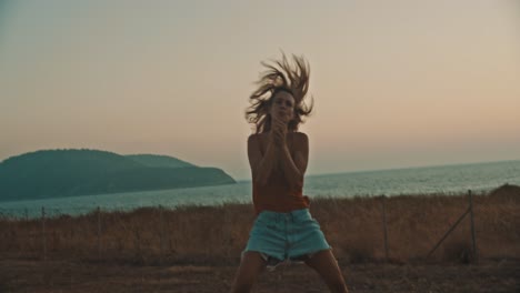 woman doing funny performance singing karaoke and dancing next to summer island sea