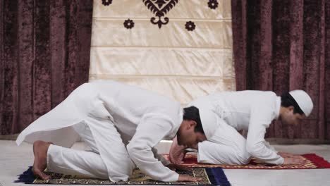 dos hombres musulmanes haciendo la oración de ramadán en casa