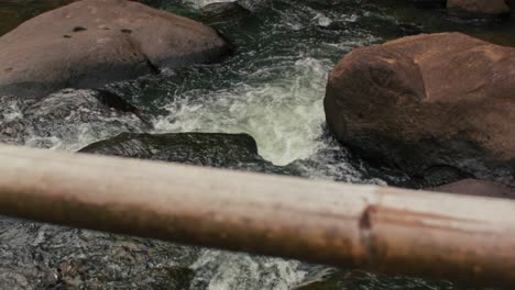 A-peaceful-river-flows-underneath-a-wooden-bridge