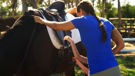 madre ayudando a su hija durante la equitación 4k
