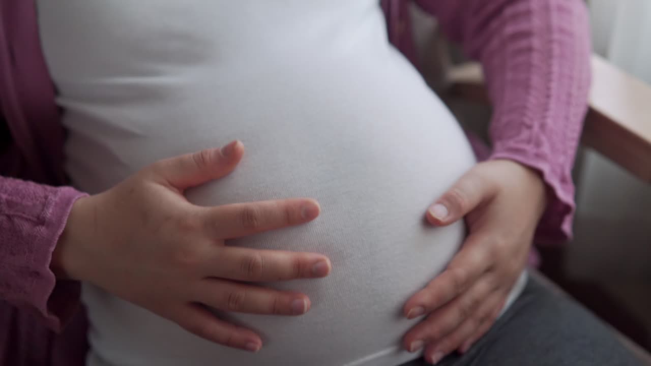 행복한 임신한 여성과 집에서 아기를 기대하고 있습니다.