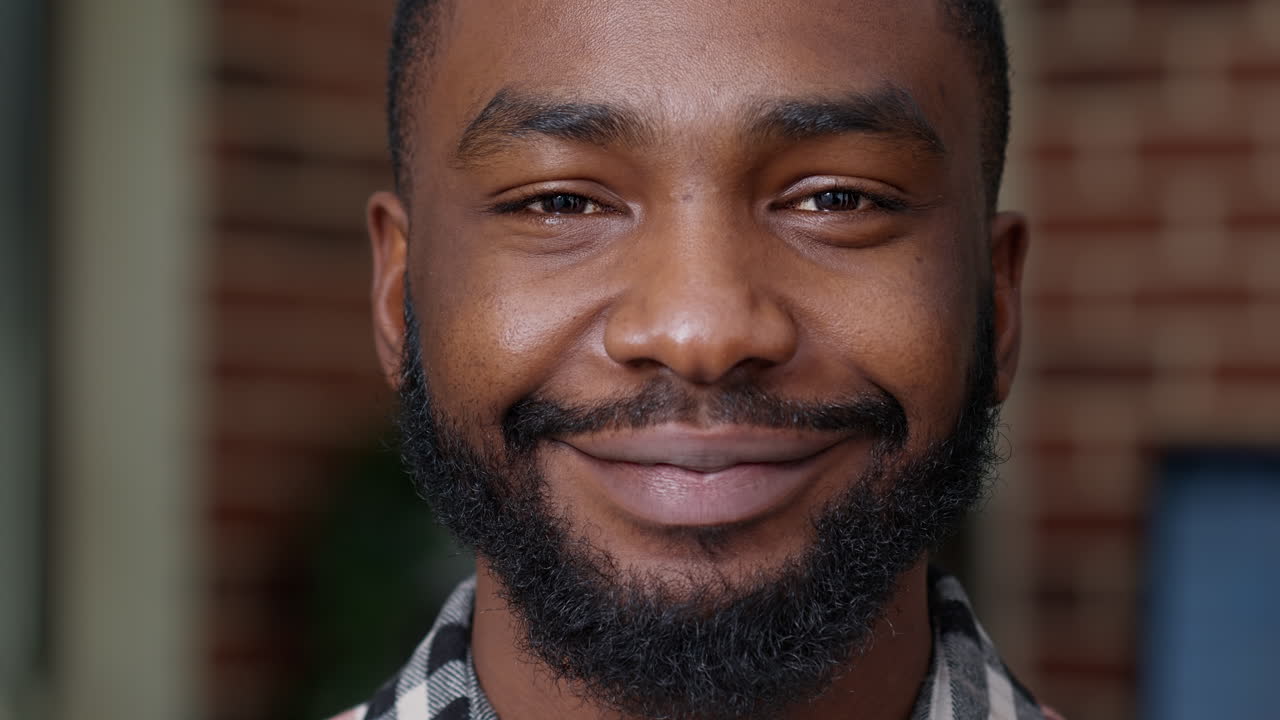 Portrait of young adult showing candid smile in front of camera