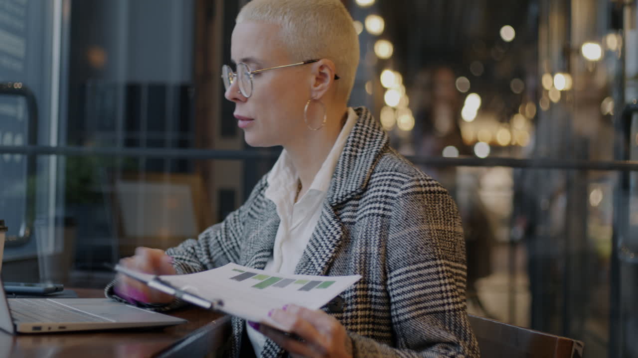 Businesswoman analyzing reports in a cafe