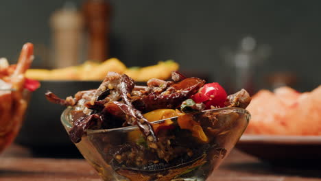taking a little bit of fermented eggplants with spices and mustard by chopstick close-up. preservation of vegetables in glass jars. fermentation preserved aubergine with greens.