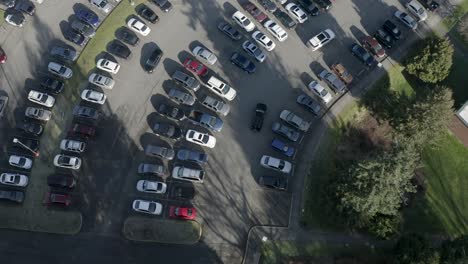 Vista-Aérea-De-Un-Auto-Pasando-Y-Buscando-Un-Espacio-En-Un-Estacionamiento---Toma-Aérea