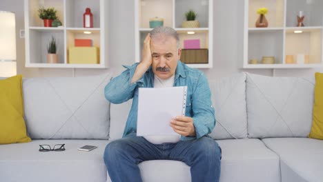 the old man looking at the papers gets sad.