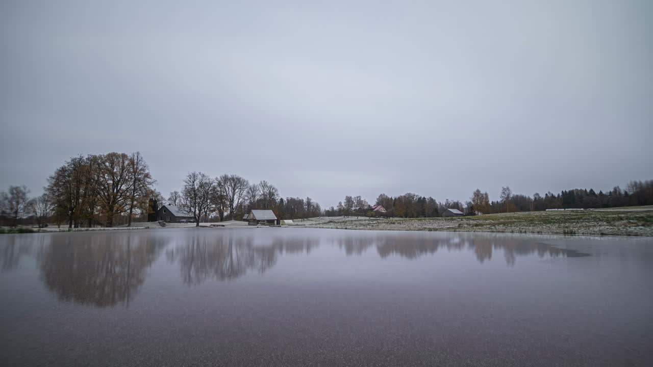 Time-lapse of changing four seasons in a year with view over dam on remote farm
