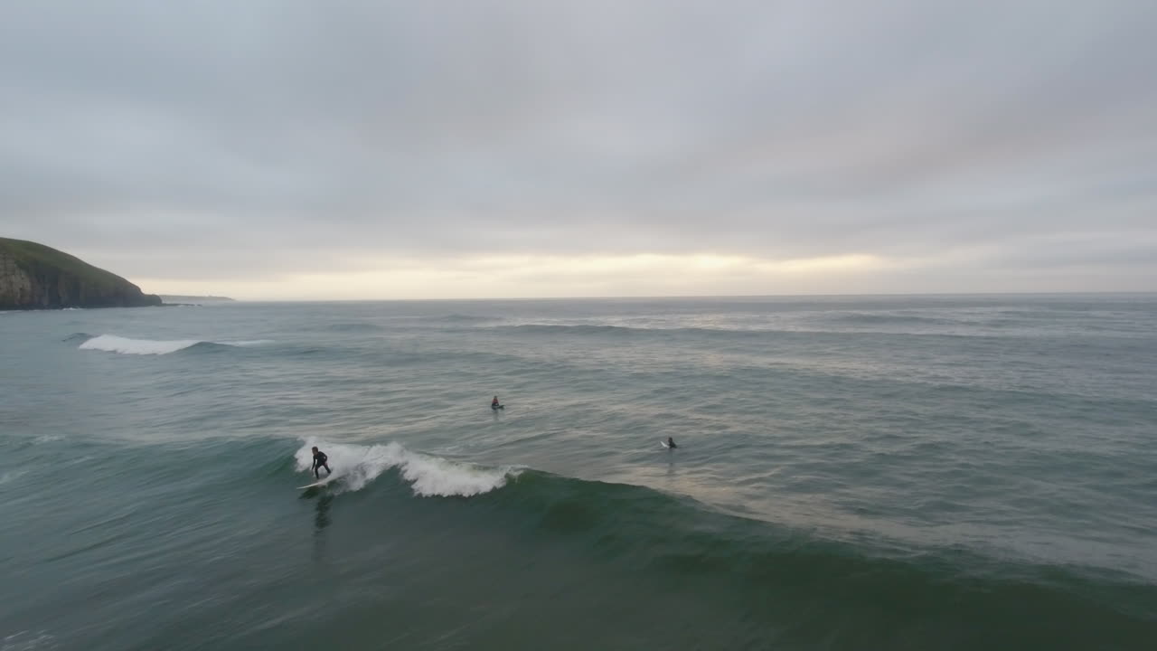 Cinematic flying of surfers surfing along coast of East London South Africa aerial