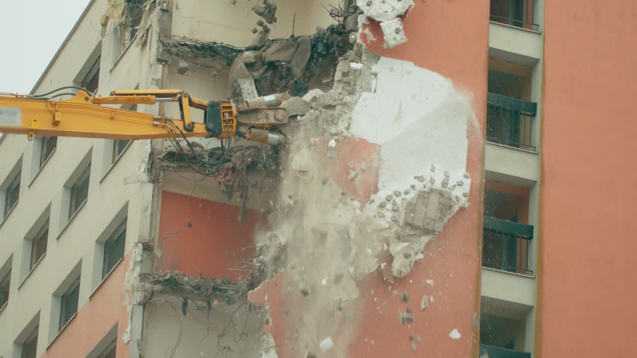 maquinaria pesada trabajando en el proceso de demolición de un edificio de hormigón en una vista de primer plano