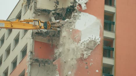 heavy machinery working on the process of demolishing a concrete building in a close-up view