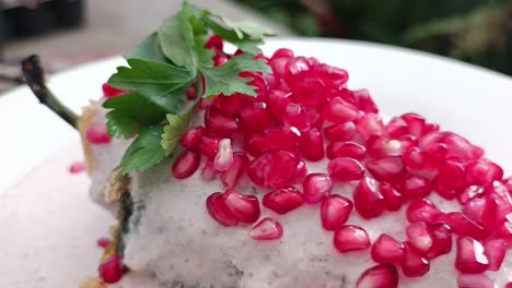 parsley and pomegranate on a mexican chile en nogada