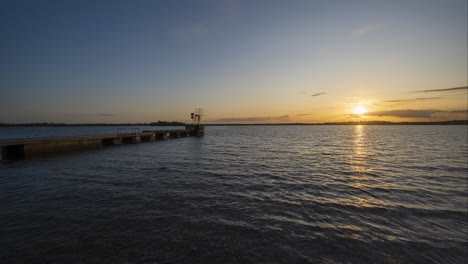 Santo-Grial-O-Lapso-De-Tiempo-De-Día-A-Noche-Del-Muelle-Del-Lago-Durante-La-Puesta-De-Sol-En-Irlanda