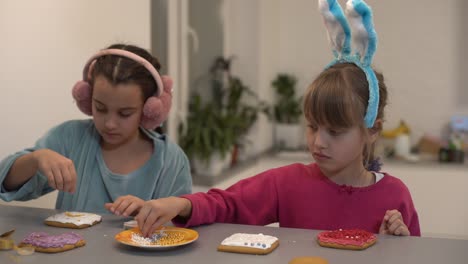 two cute sisters make and decorate cookies