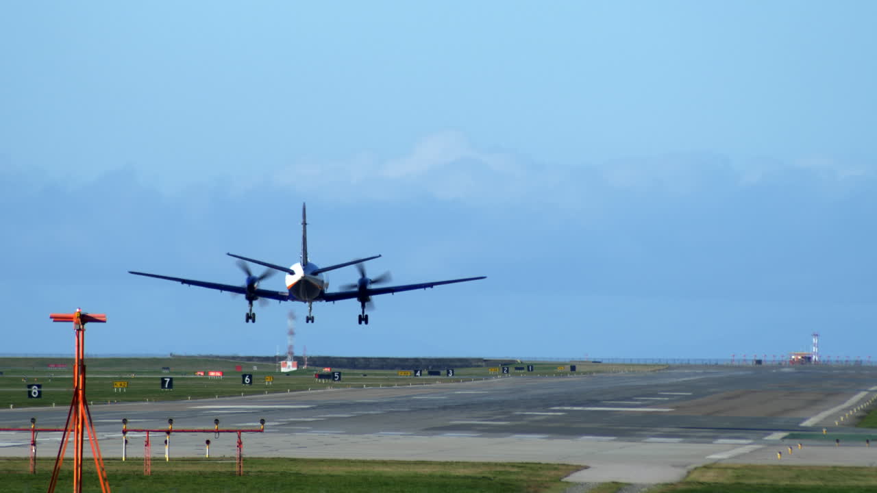 un avión de hélice turbohélice aterrizando en la pista, toma trasera