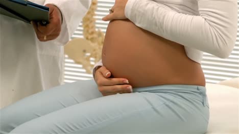 Arzt-Zeigt-Seiner-Schwangeren-Patientin-Seine-Notizen