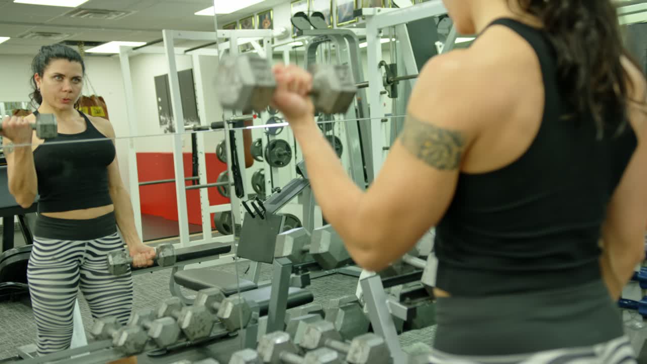 Chica joven, segura de sí misma y decidida entrenando en el gimnasio
