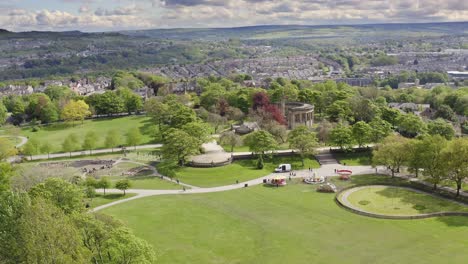 Aerial-shot-flying-over-English-town-and-park-with-woodland-in-Huddersfield