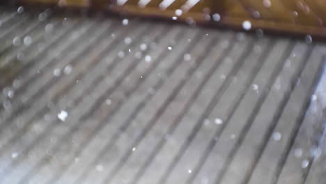 Snow-falling-in-slow-motion-on-the-terrace-of-wooden-cabin