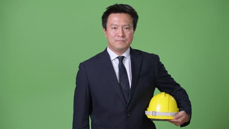 녹색 배경에 성숙한 일본 사업가