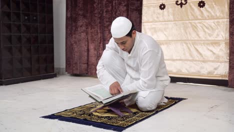 hombre indio leyendo el corán en casa