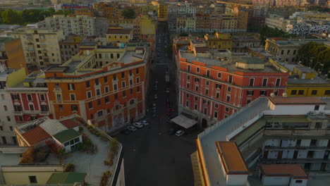 Imágenes-Aéreas-Descendentes-De-Cruce-Entre-Bloques-De-Casas-En-La-Ciudad.-Los-Delanteros-Vuelan-Por-Encima-De-La-Calle.-Roma,-Italia