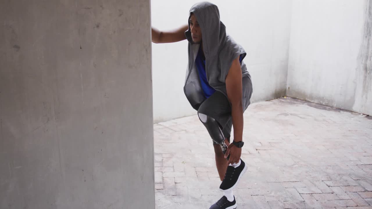 vista lateral hombre con pierna protésica estirándose