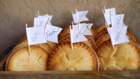 slow motion shot of a small box of different flavored miniature pies