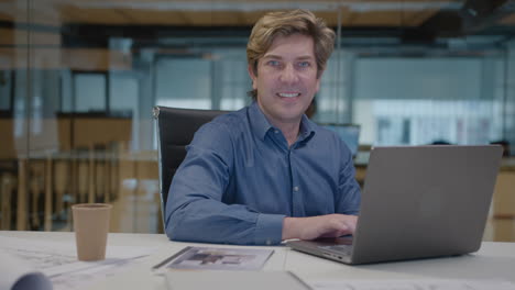 mid-aged architect working on laptop at office desk