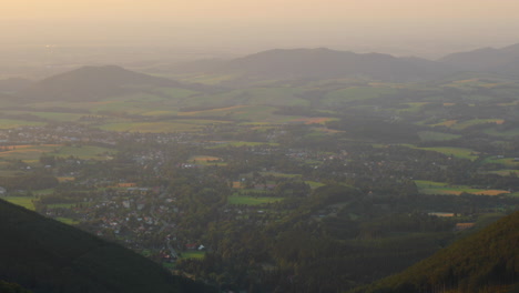 Gezoomt-In-Ein-Tal,-Das-Unter-Einem-Berg-Voller-Familienhäuser-Liegt,-Aufgenommen-Während-Des-Sonnenuntergangs,-Wenn-Schatten-Auf-Den-Boden-Projiziert-Werden