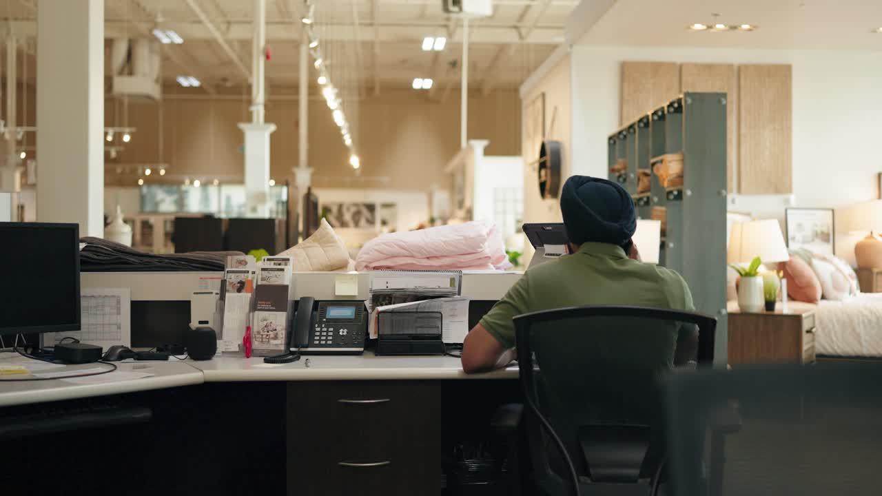 Middle Eastern Man in Turban Talking on Phone at Desk in Retail Store