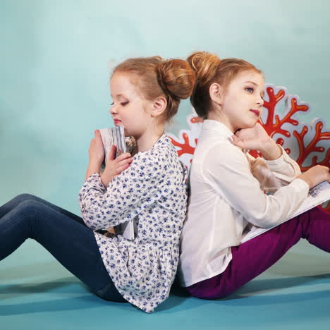 cute little girls are reading books. happy childhood. studio shooting of children square video