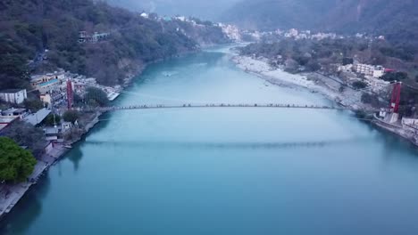 iron suspension ram jhula bridge across ganges river in rishikesh, uttarakhand, india - aerial drone shot