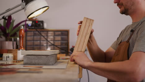 un cuero instala una herramienta para procesar el cuero en el taller