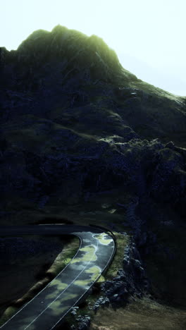 a winding mountain road with a mountain peak in the background