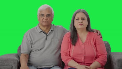 una pareja de ancianos indios enojados mirando la pantalla verde de la cámara