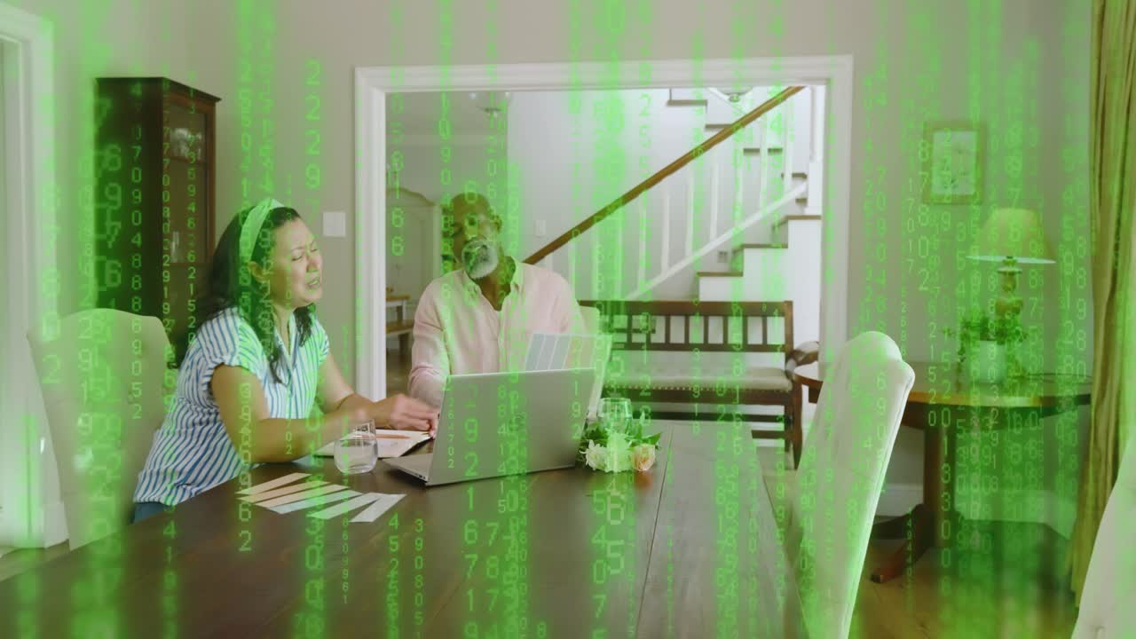 Woman typing at laptop initiating growing green code overlay, couple reviewing tech papers