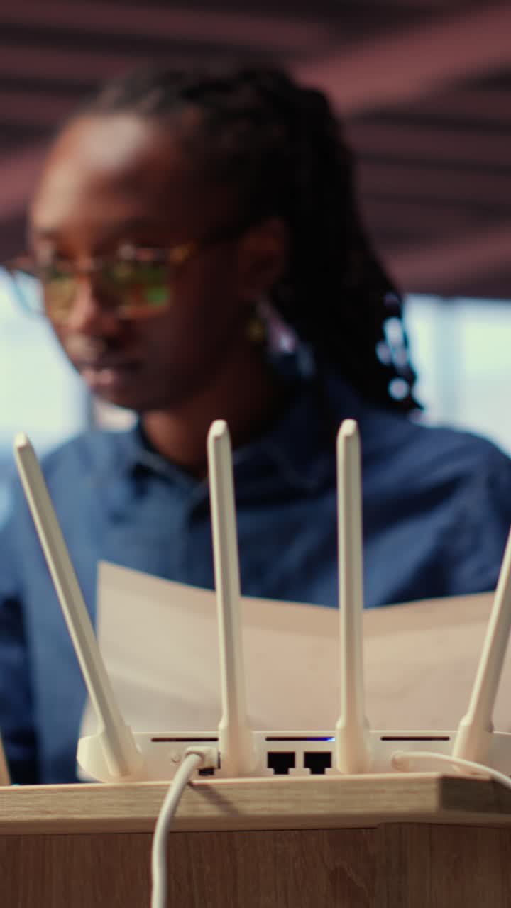 African American Woman Working on Laptop with Wi-Fi Router