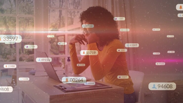 Leaning woman wearing yellow top reacting to laptop at home office near window with floating alerts