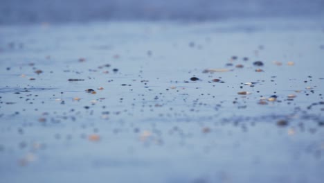 close up abstract shot of wind rippling the water along the a beach