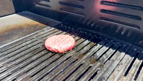 flames rise as patty cooks on grill