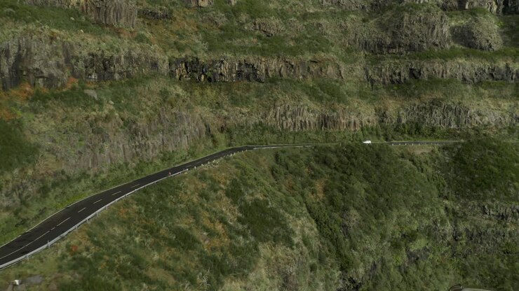 Vehicle driving on high mountain road in Madeira, steep slope, aerial