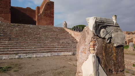 capitolium, roman temple located in ostia antica, a huge and world famous archaeological site from ancient rome, tilt shot with stele on the foreground