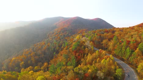 drone slowly flying above the north georgia mountains full of fall colors at sunset