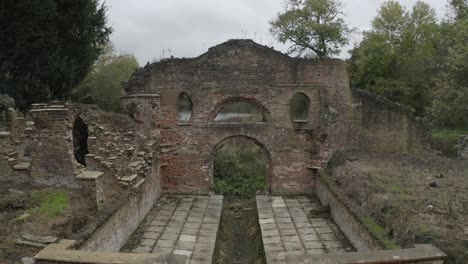 edificio abandonado en el parque de londres, rodeado de árboles y marismas