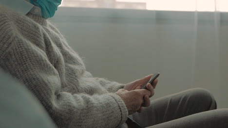 elderly man with face mask using a smartphone